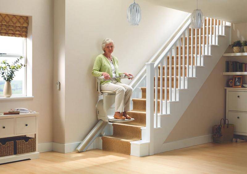 Stannah Siena stairlift in use on a straight staircase